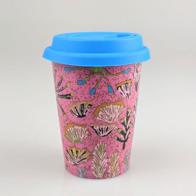 Coffee cup with pink and blue indigenous design printed on it.
