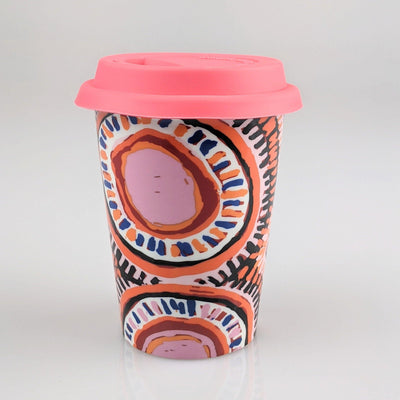 Coffee cup with pink and orange indigenous design printed on it.