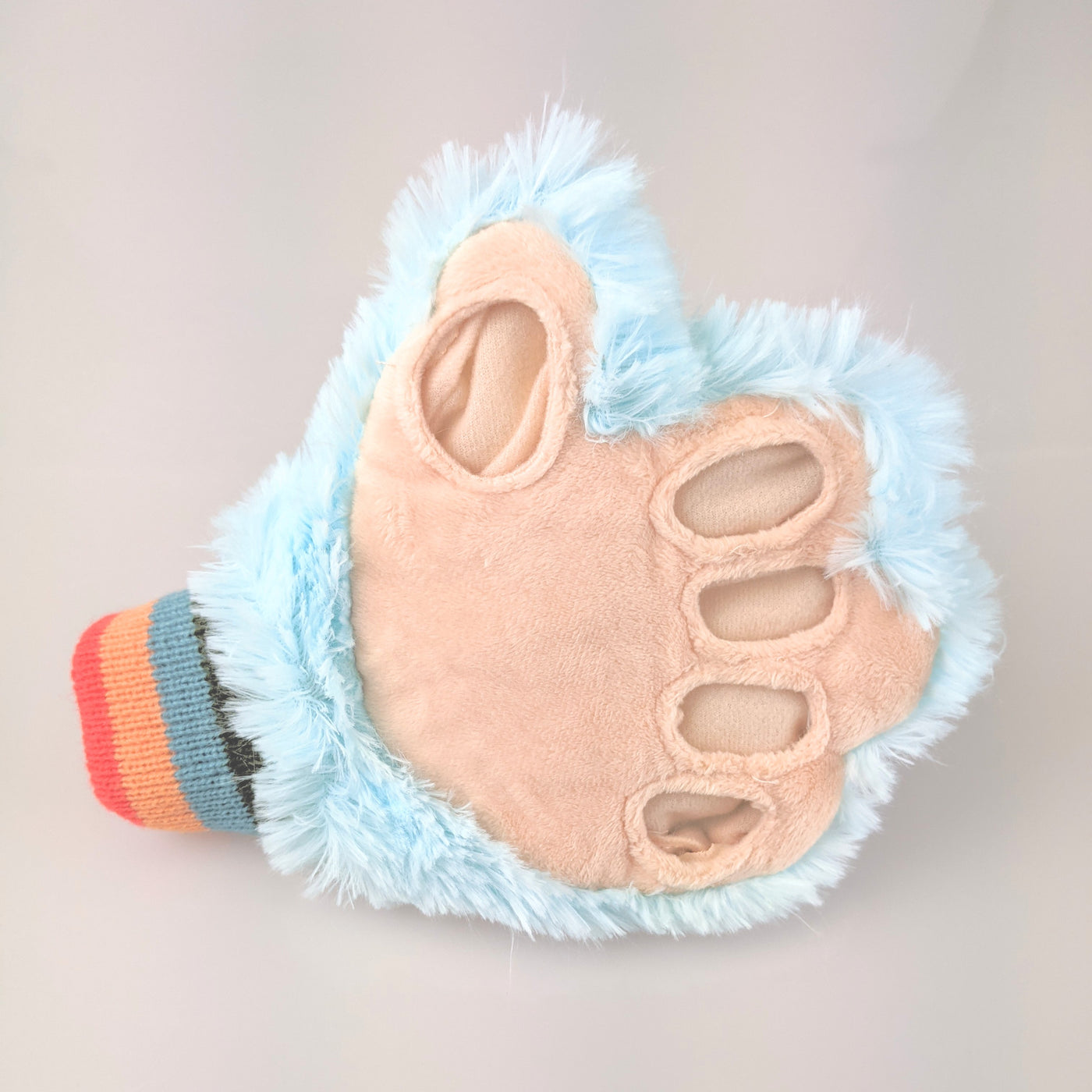 tickle monster glove with blue fluffy outer and holes for fingers.