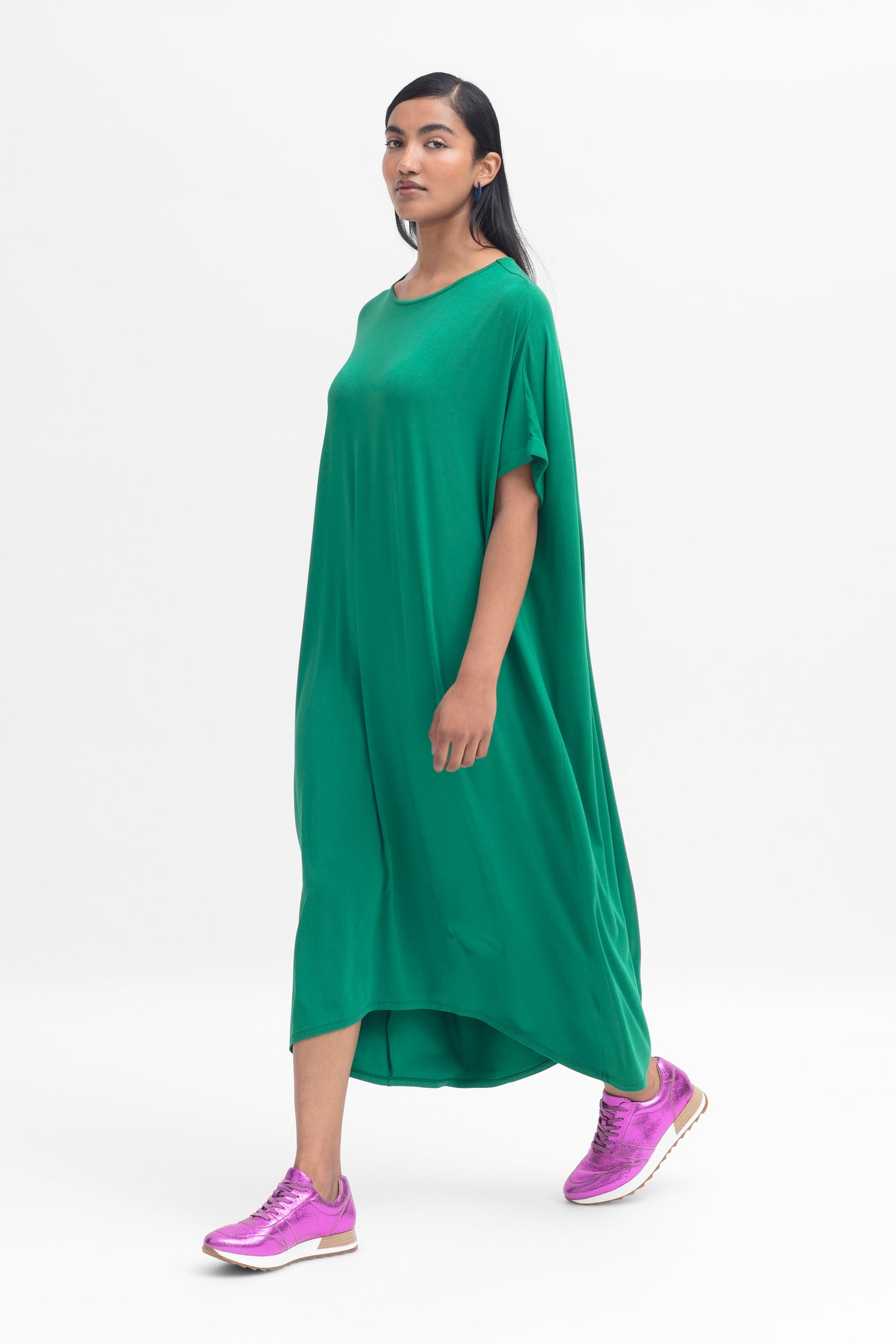 Model wearing cedar green telse dress with pink sneakers